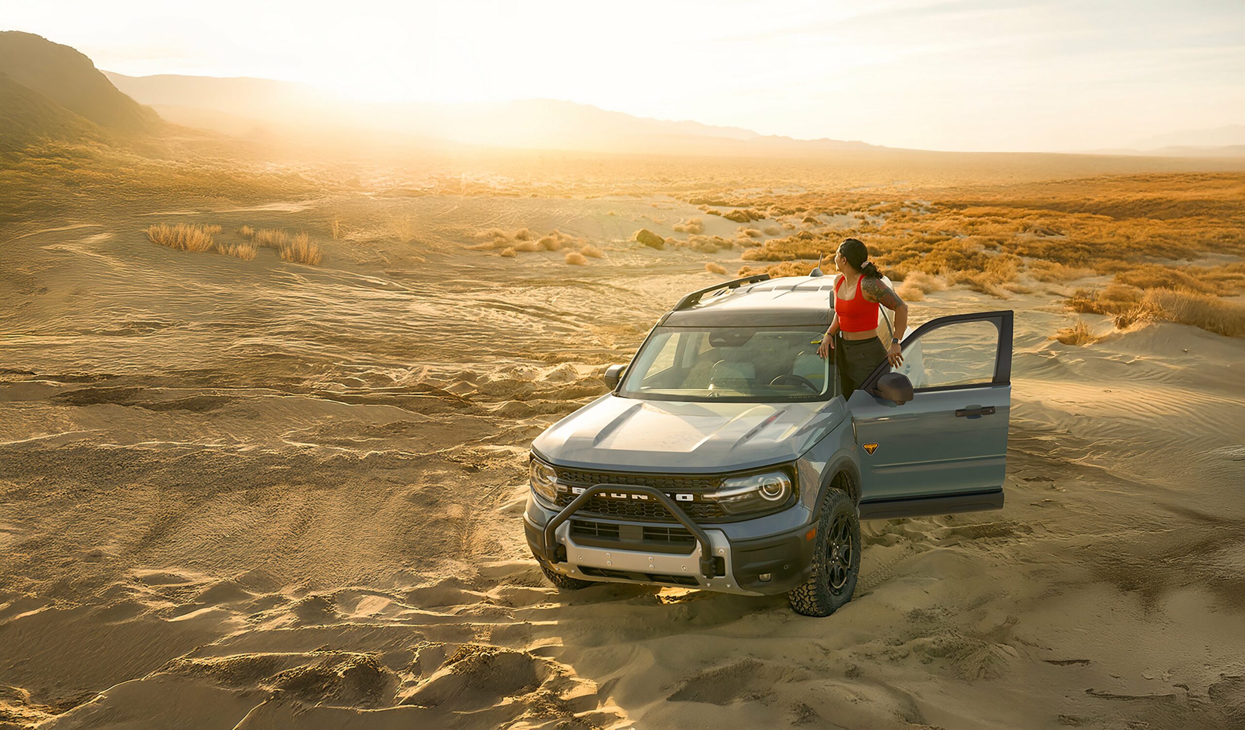 A 2026 Ford Bronco Sport Badlands parked on desert sand with a door open