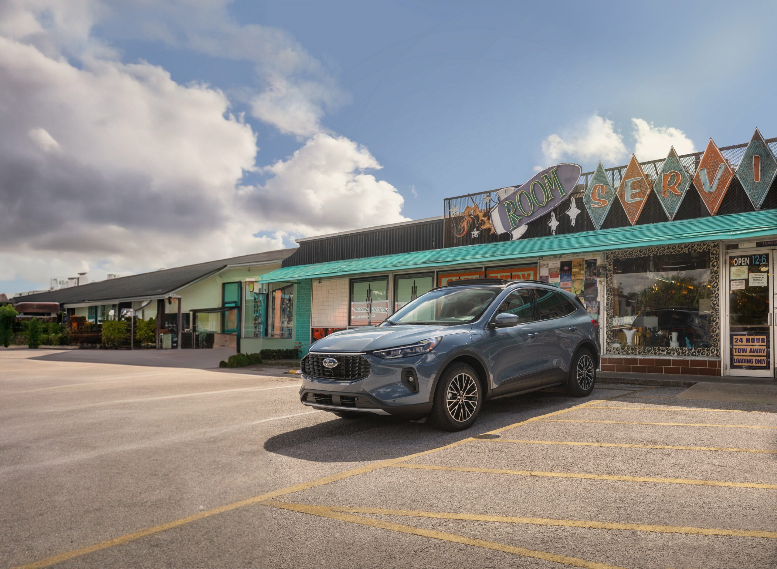 A 2026 Ford Escape Plug-in Hybrid in Vapor Blue outside a row of storefronts
