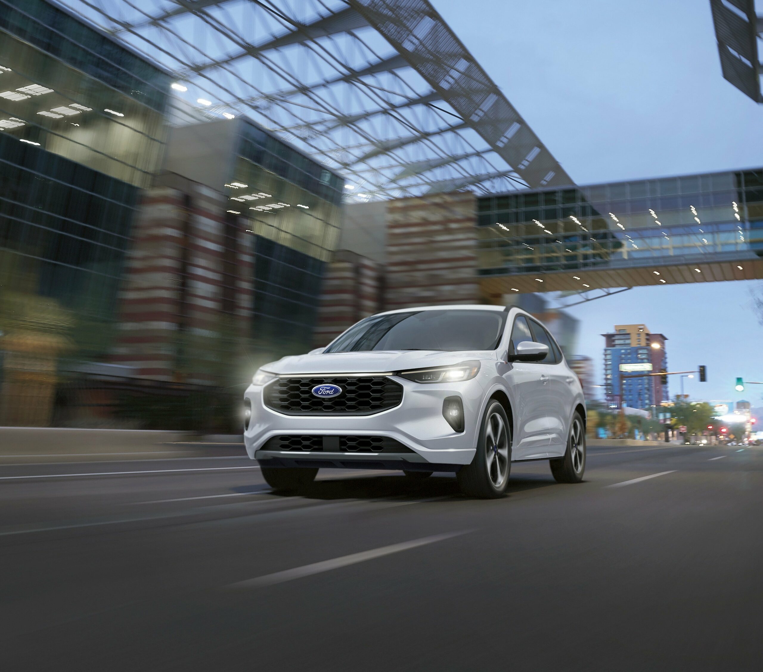 A white 2026 Ford Escape driving under a bridge