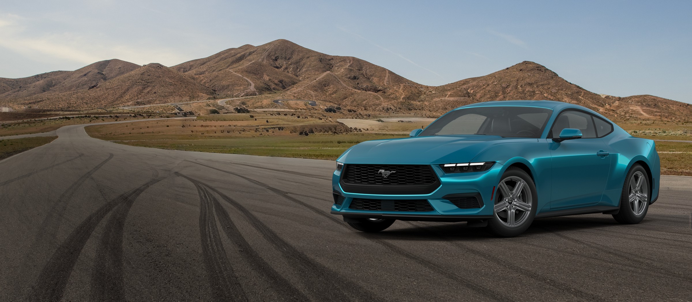 A teal 2026 Ford Mustang EcoBoost Premium Fastback on a desert road