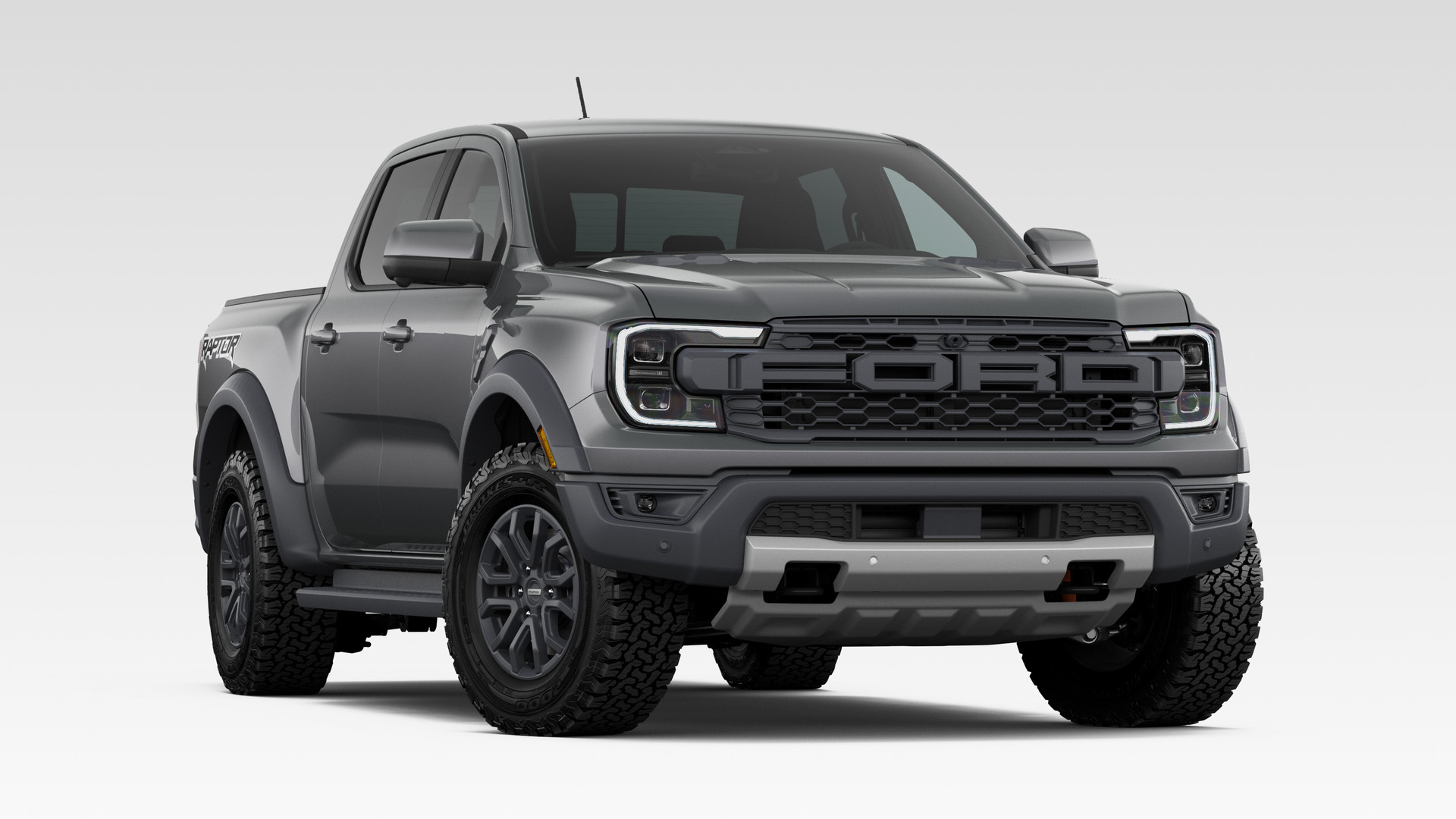 A Carbonized Gray Metallic 2026 Ford Ranger Raptor SuperCrew, front three-quarter studio render, block FORD grille lettering, flared fenders, side steps and all-terrain tires
