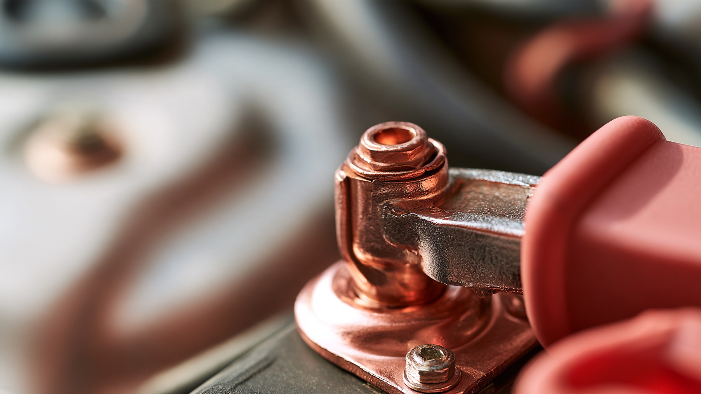 Close-up of a car battery terminal post with the cable clamp bolted on