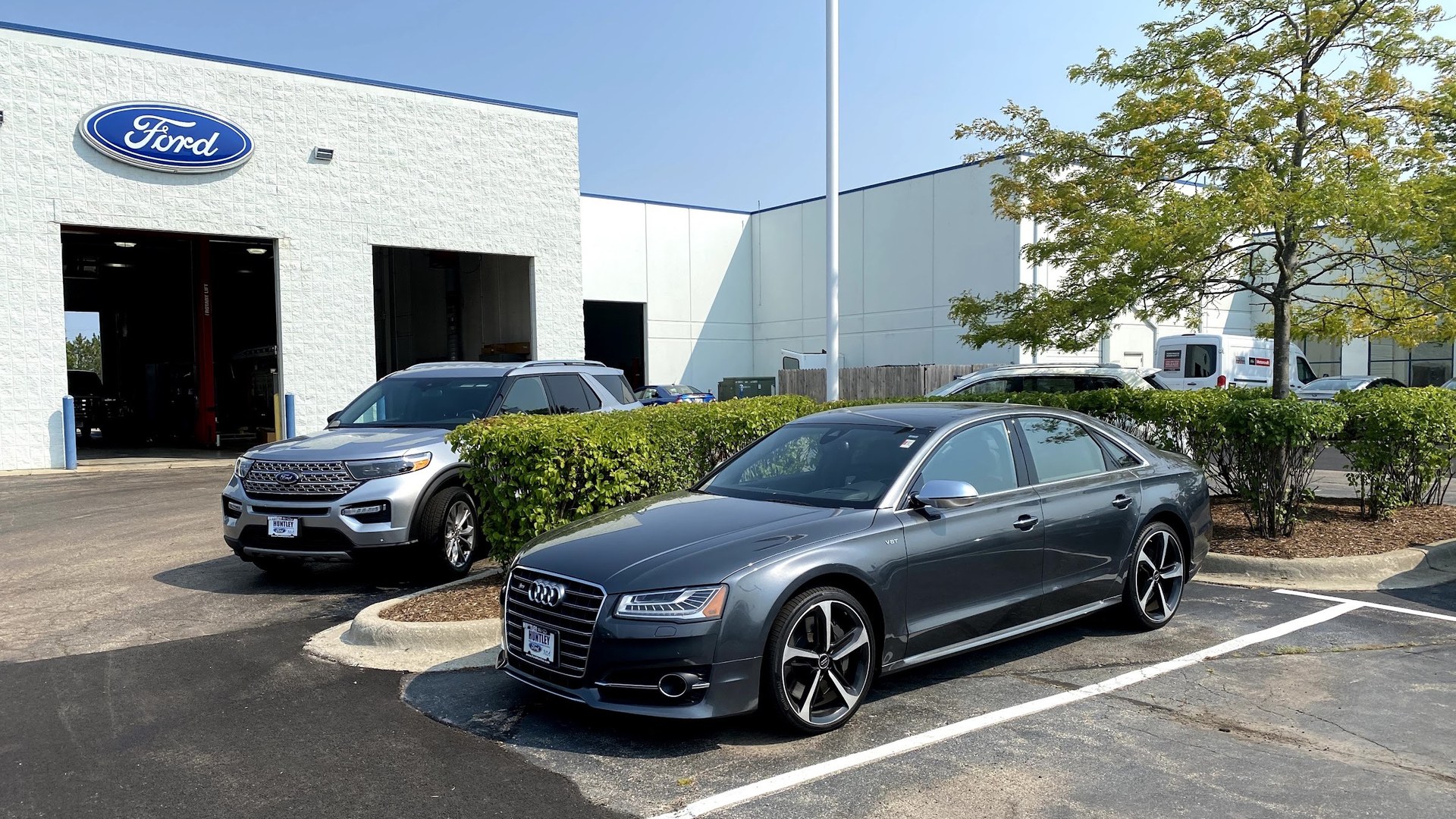 The service drive at Huntley Ford on a clear morning, with two bay doors open under the Ford oval.